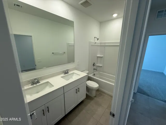 a bathroom with a granite countertop sink mirror and toilet