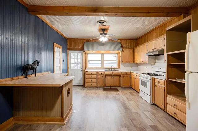 a kitchen with kitchen island a stove a sink and a refrigerator