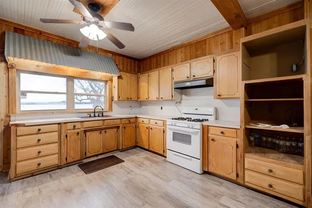 a kitchen with granite countertop a stove a sink and a refrigerator