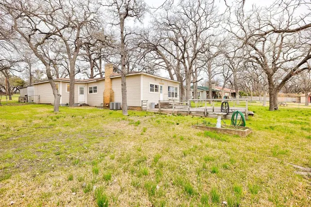 a white house that has a tree in front of a white house