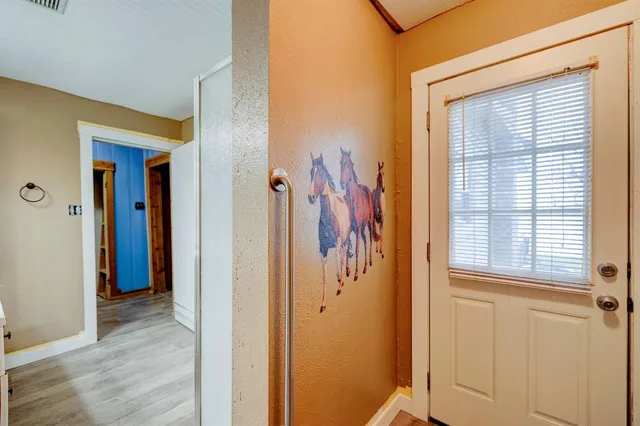 a view of a hallway with wooden floor and closet