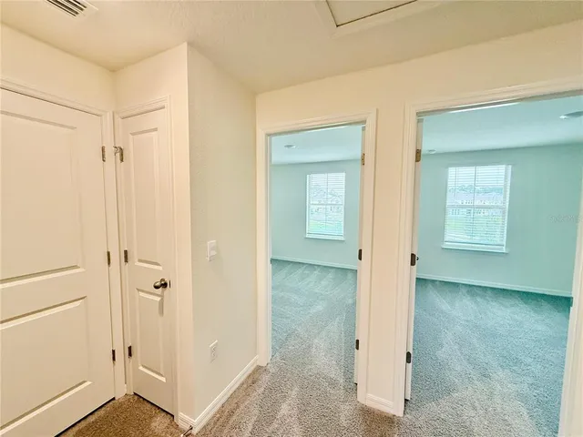 a view of a livingroom with wooden floor and a bathroom