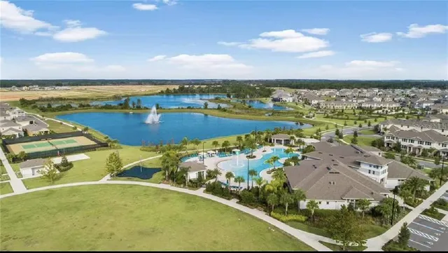 an aerial view of a house with a garden and lake view