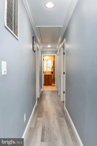 a view of a hallway with wooden shelves and a window