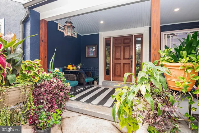 a vase of flowers sitting on a table in front of a house