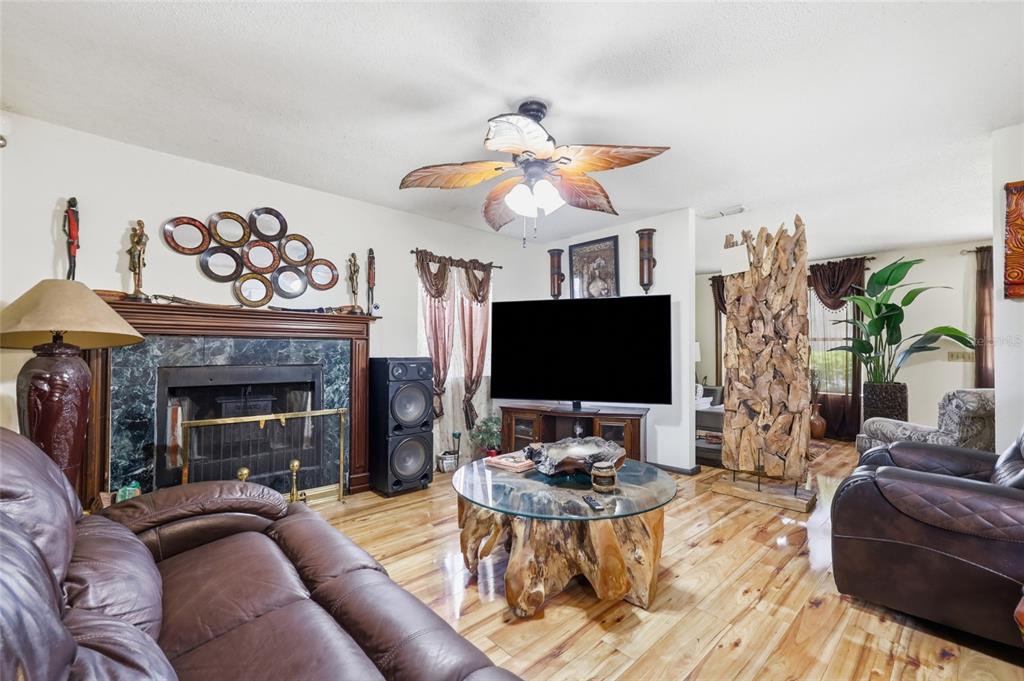 3027 Queens Gate Road Orlando, FL 32818 - Photo 13 of 34 a living room with furniture a fireplace and a flat screen tv