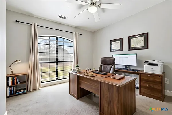 a view of a workspace with furniture and a window