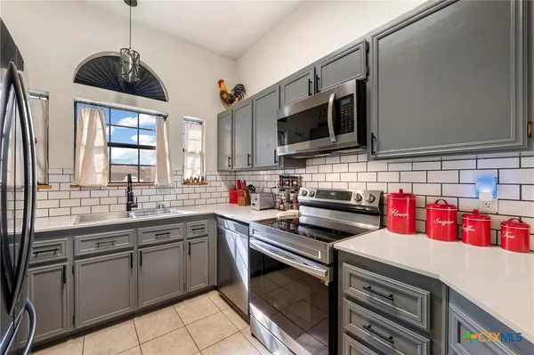 a kitchen that has a sink and a stove top oven