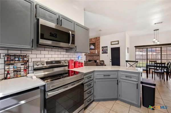 a kitchen with stainless steel appliances a stove microwave and cabinets