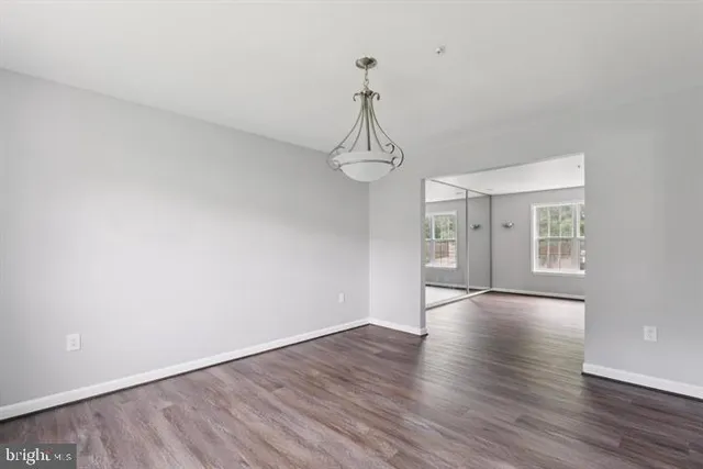 a view of empty room with wooden floor and ceiling fan