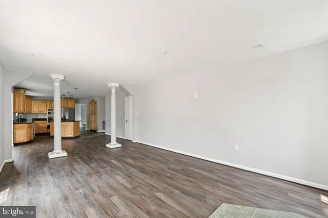 a view of a big room with wooden floor and windows