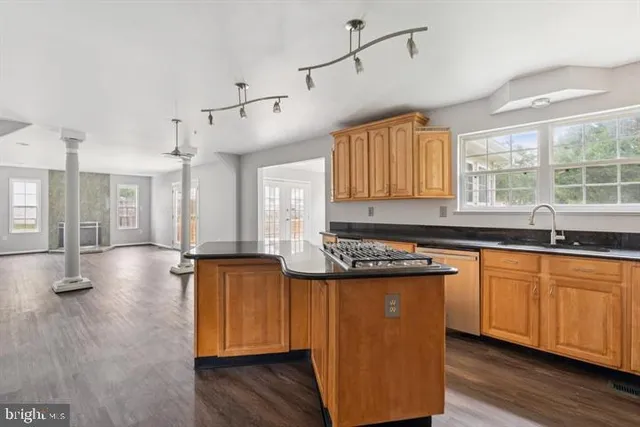a kitchen with stainless steel appliances granite countertop wooden floors and sink