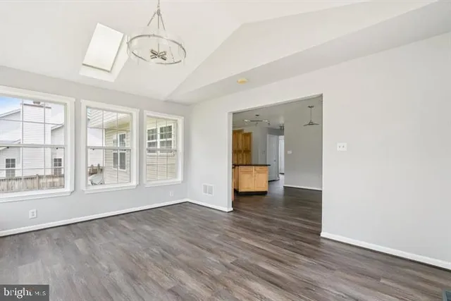 a view of empty room with wooden floor and windows