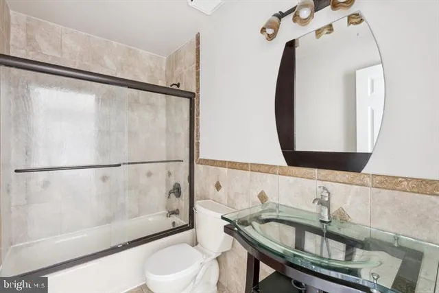 a bathroom with a sink a toilet and a mirror