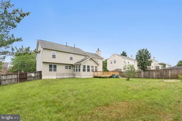 a view of a house with a big yard and large trees