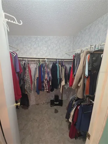 a view of walk in closet with clothes