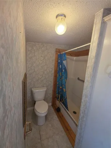 a bathroom with a granite countertop toilet and a shower