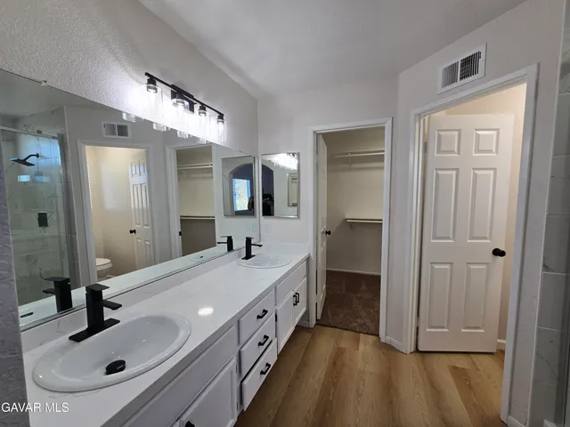 a bathroom with double vanity and a mirror