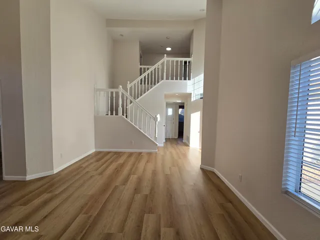 a view of a room with wooden floor and chandelier