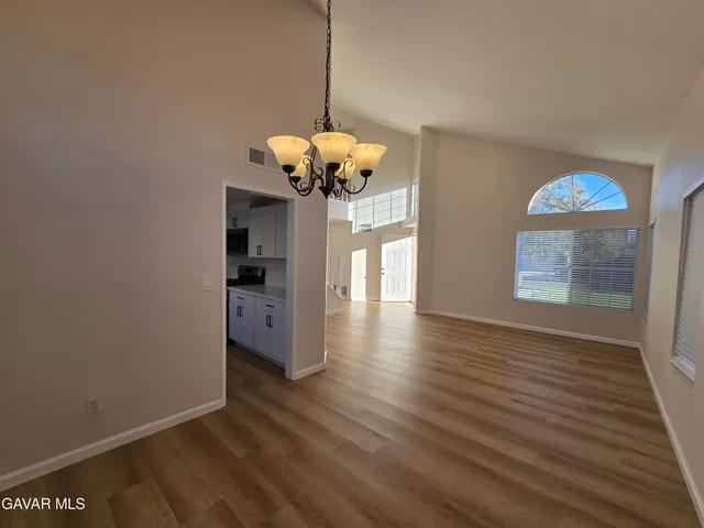 a large kitchen with stainless steel appliances granite countertop a lot of counter space and wooden floors