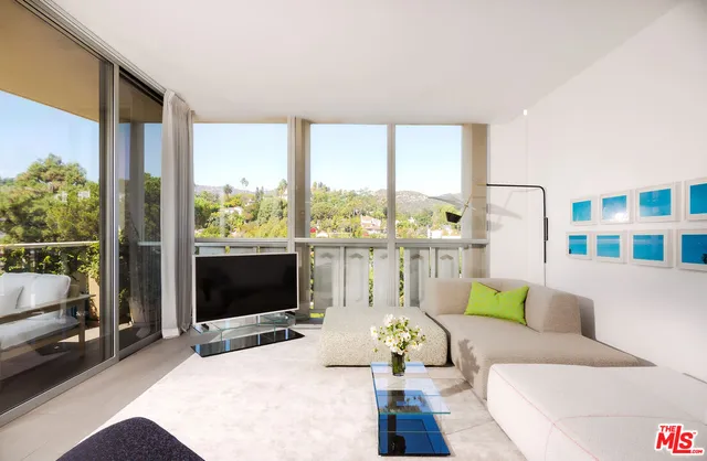 a living room with furniture tv and a floor to ceiling window