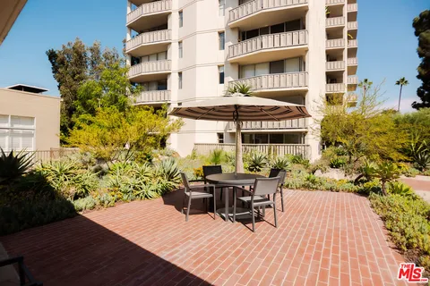 a view of a patio with table and chairs and potted plants