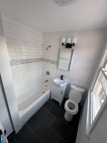 a bathroom with a tub sink and mirror