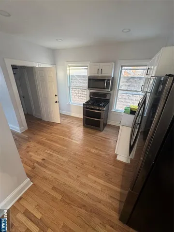 a view of kitchen with wooden floor and electronic appliances