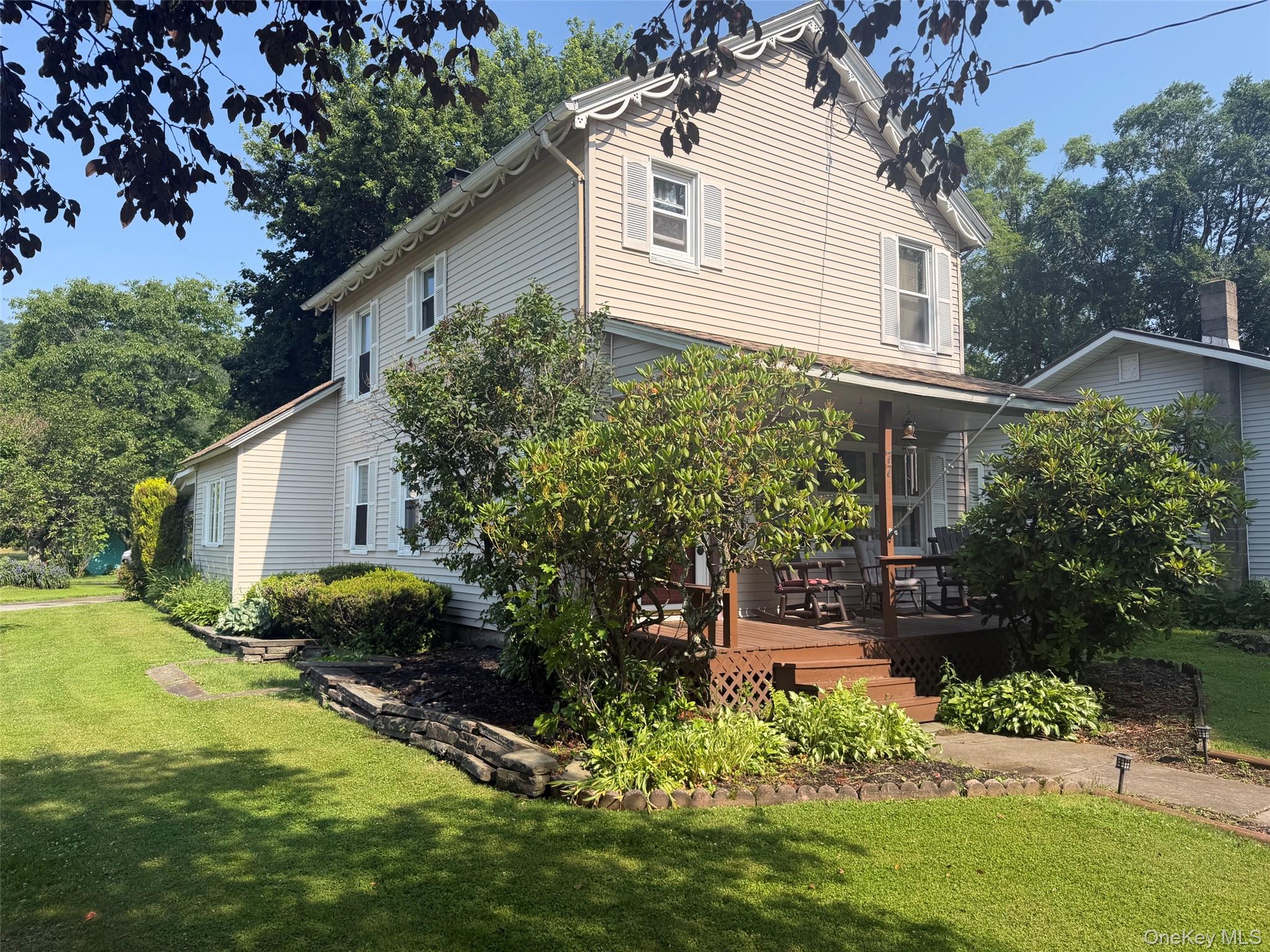 77 Rockland Road Roscoe, NY 12776 - Photo 2 of 20 Two-story residence featuring light-colored siding, white window shutters, and decorative scalloped trim under the eaves