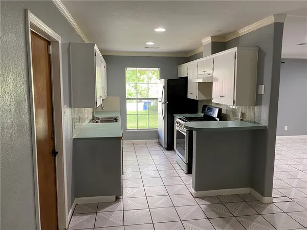 a kitchen with stainless steel appliances granite countertop a refrigerator and a sink
