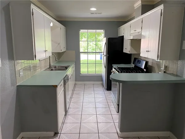 a kitchen with a sink stove and cabinets