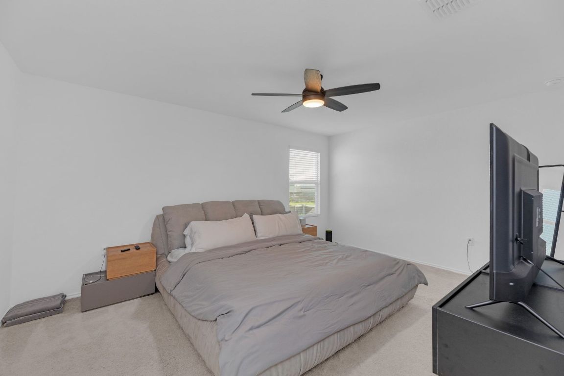 2324 Willkomen Way Pflugerville, TX 78660 - Photo 10 of 21 a bedroom with a bed and a flat screen tv