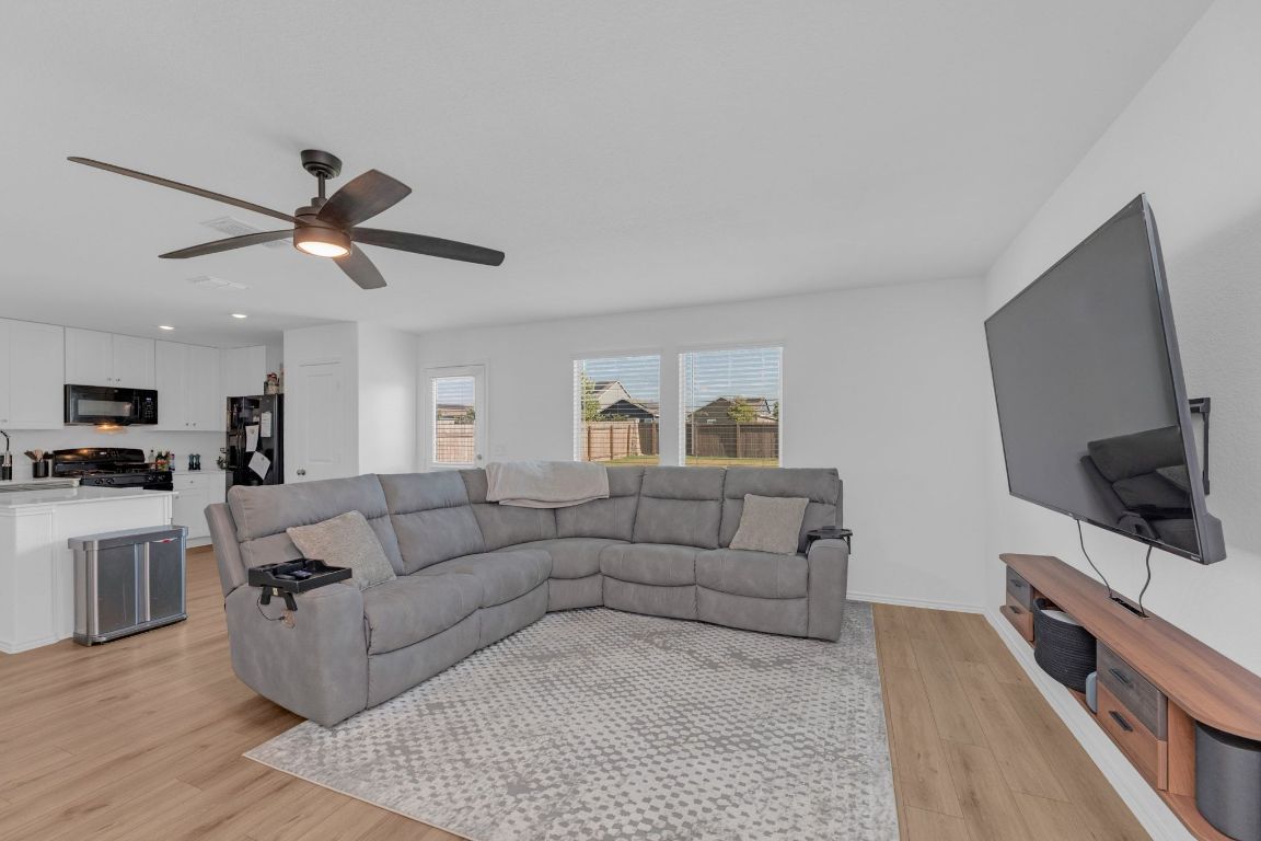 2324 Willkomen Way Pflugerville, TX 78660 - Photo 3 of 21 a living room with furniture and a flat screen tv