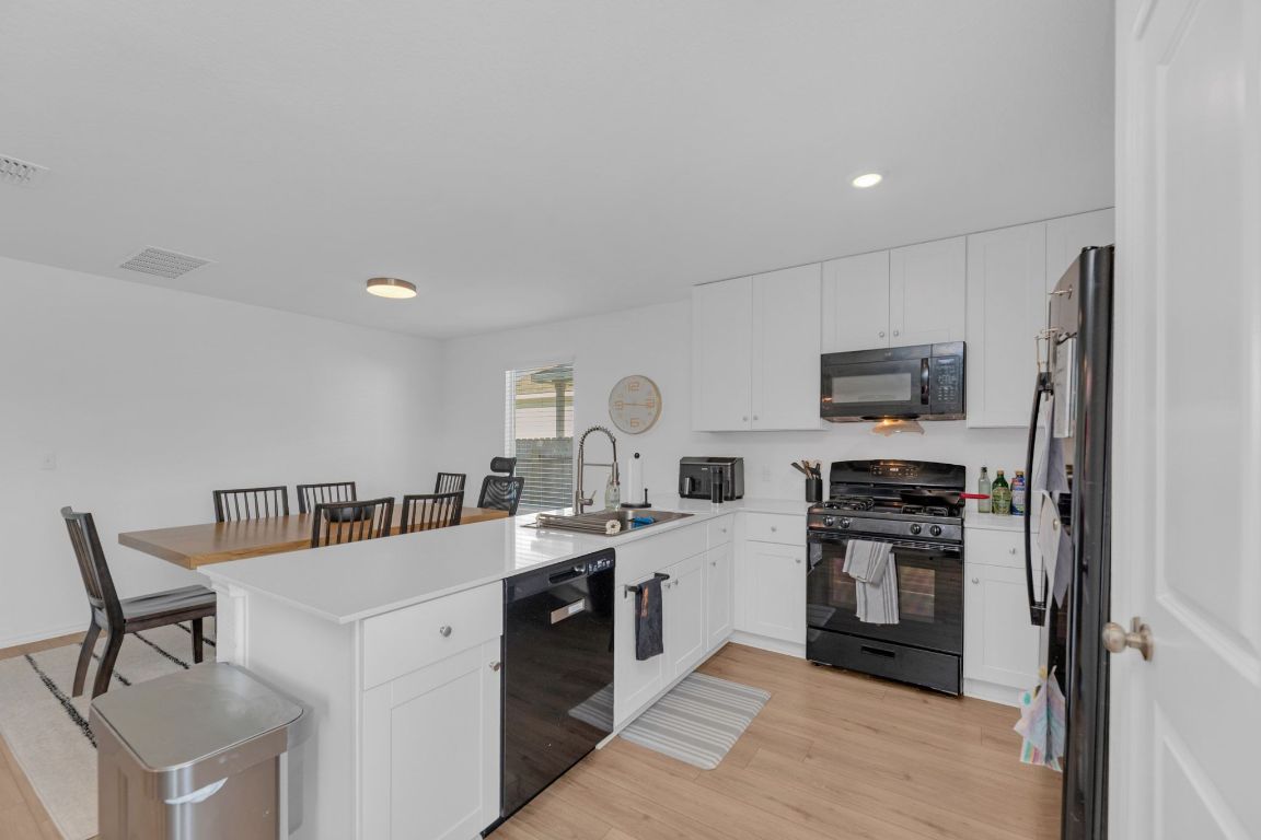 2324 Willkomen Way Pflugerville, TX 78660 - Photo 6 of 21 a kitchen with cabinets and stainless steel appliances