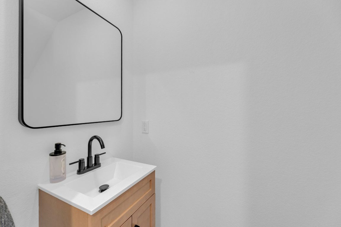 2324 Willkomen Way Pflugerville, TX 78660 - Photo 8 of 21 a bathroom with a sink and a mirror