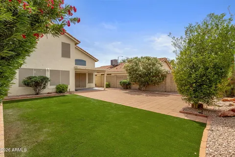 a front view of a house with a yard and a garden