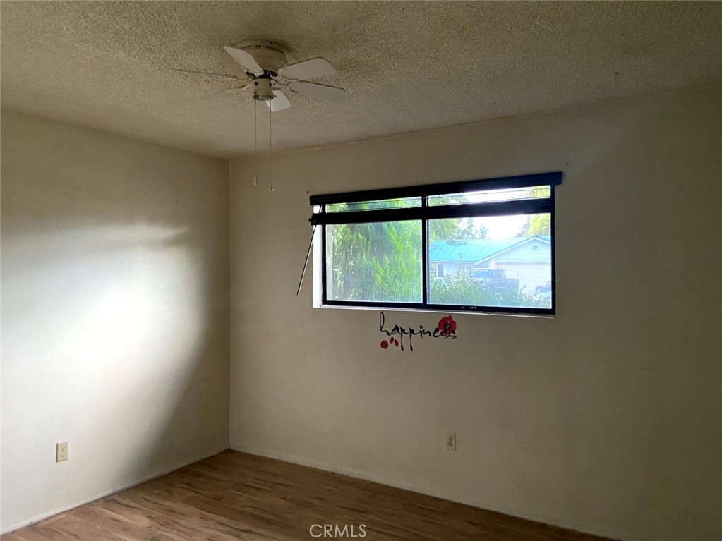 204 Patterson Avenue Loyalton, CA 96118 - Photo 3 of 12 an empty room with wooden floor and windows