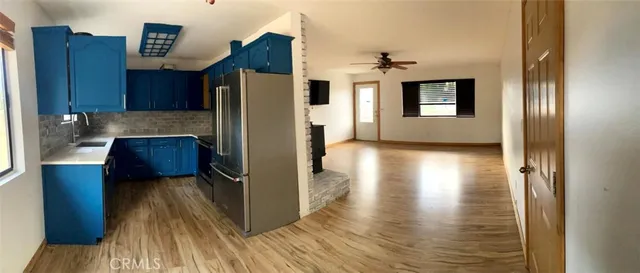 a kitchen with kitchen island wooden floors appliances and cabinets