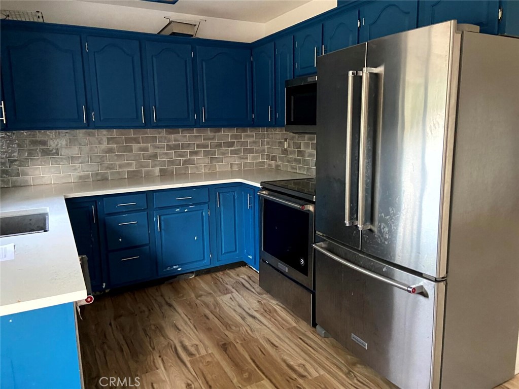 204 Patterson Avenue Loyalton, CA 96118 - Photo 8 of 12 a kitchen with a refrigerator and wooden cabinets
