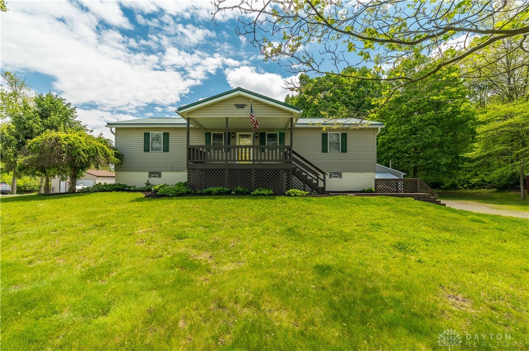 This charming home offers a welcoming facade with a spacious front yard and mature trees.