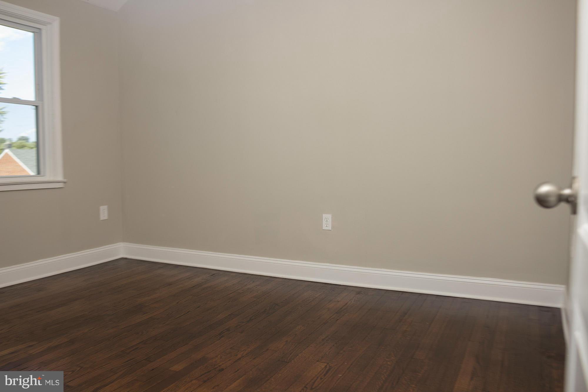1021 Upnor Road Baltimore, MD 21212 - Photo 13 of 24 a view of an empty room with wooden floor and a window