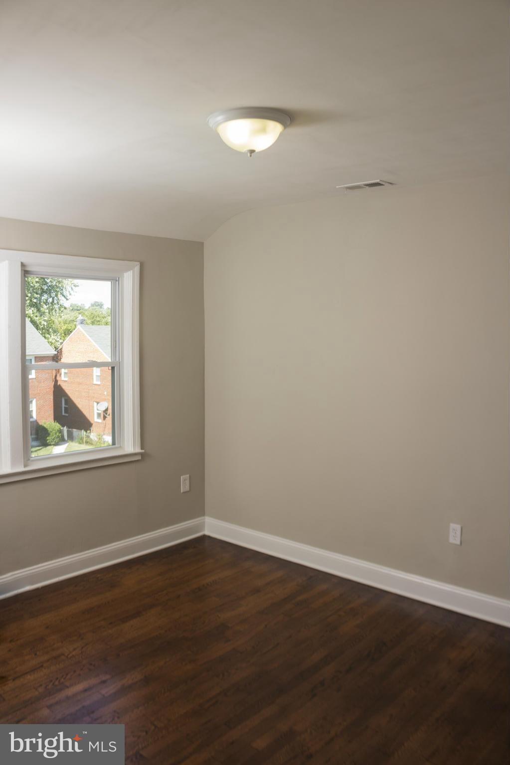 1021 Upnor Road Baltimore, MD 21212 - Photo 14 of 24 a view of an empty room with wooden floor and a window