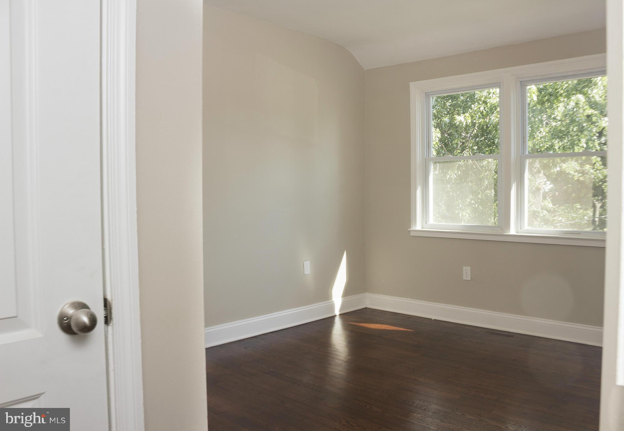 1021 Upnor Road Baltimore, MD 21212 - Photo 17 of 24 a view of an empty room with wooden floor and a window