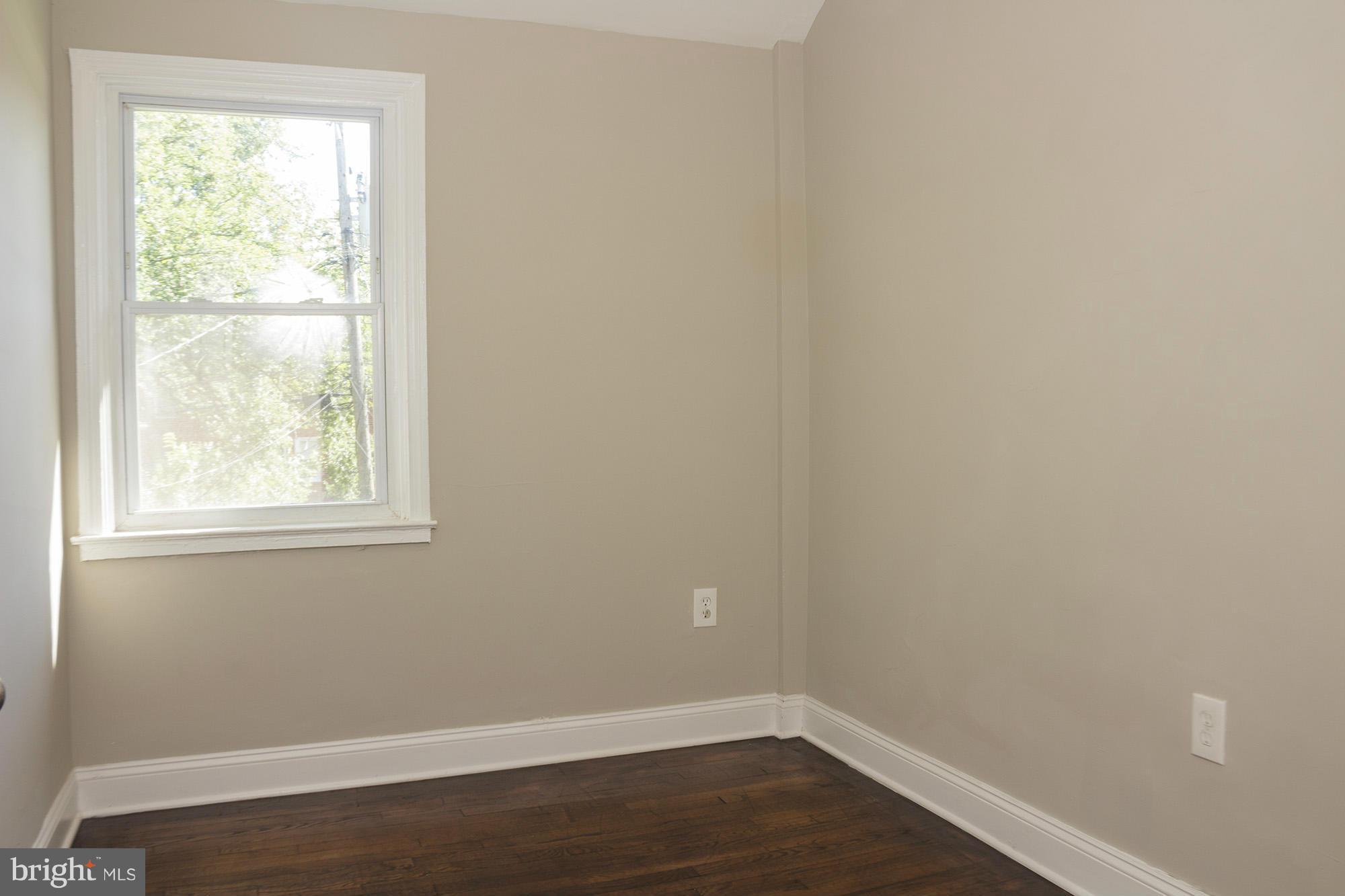 1021 Upnor Road Baltimore, MD 21212 - Photo 18 of 24 an empty room with wooden floor and windows