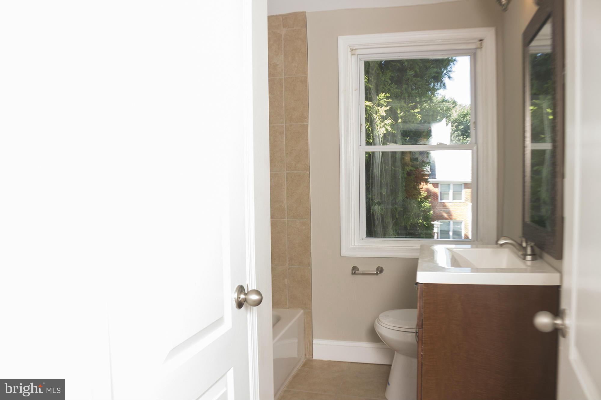 1021 Upnor Road Baltimore, MD 21212 - Photo 23 of 24 a bathroom with a sink a toilet and a mirror
