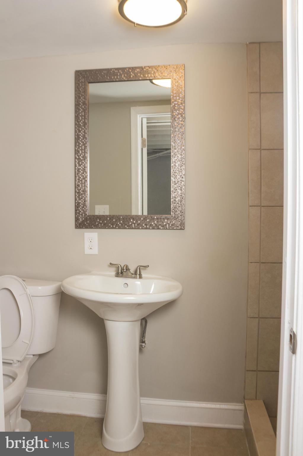 1021 Upnor Road Baltimore, MD 21212 - Photo 24 of 24 a bathroom with a sink a mirror and vanity