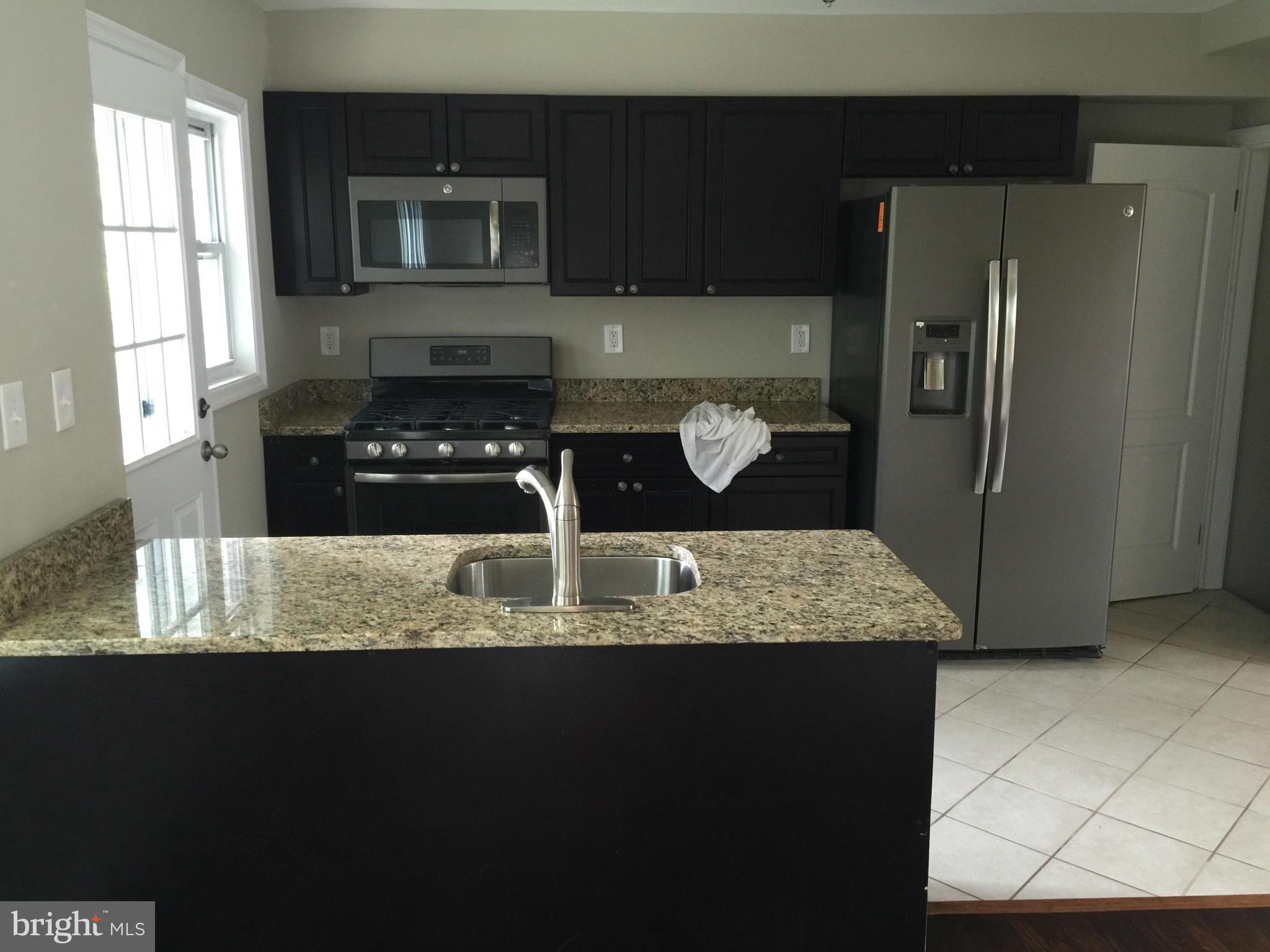 1021 Upnor Road Baltimore, MD 21212 - Photo 4 of 24 a kitchen with stainless steel appliances granite countertop a refrigerator and a stove