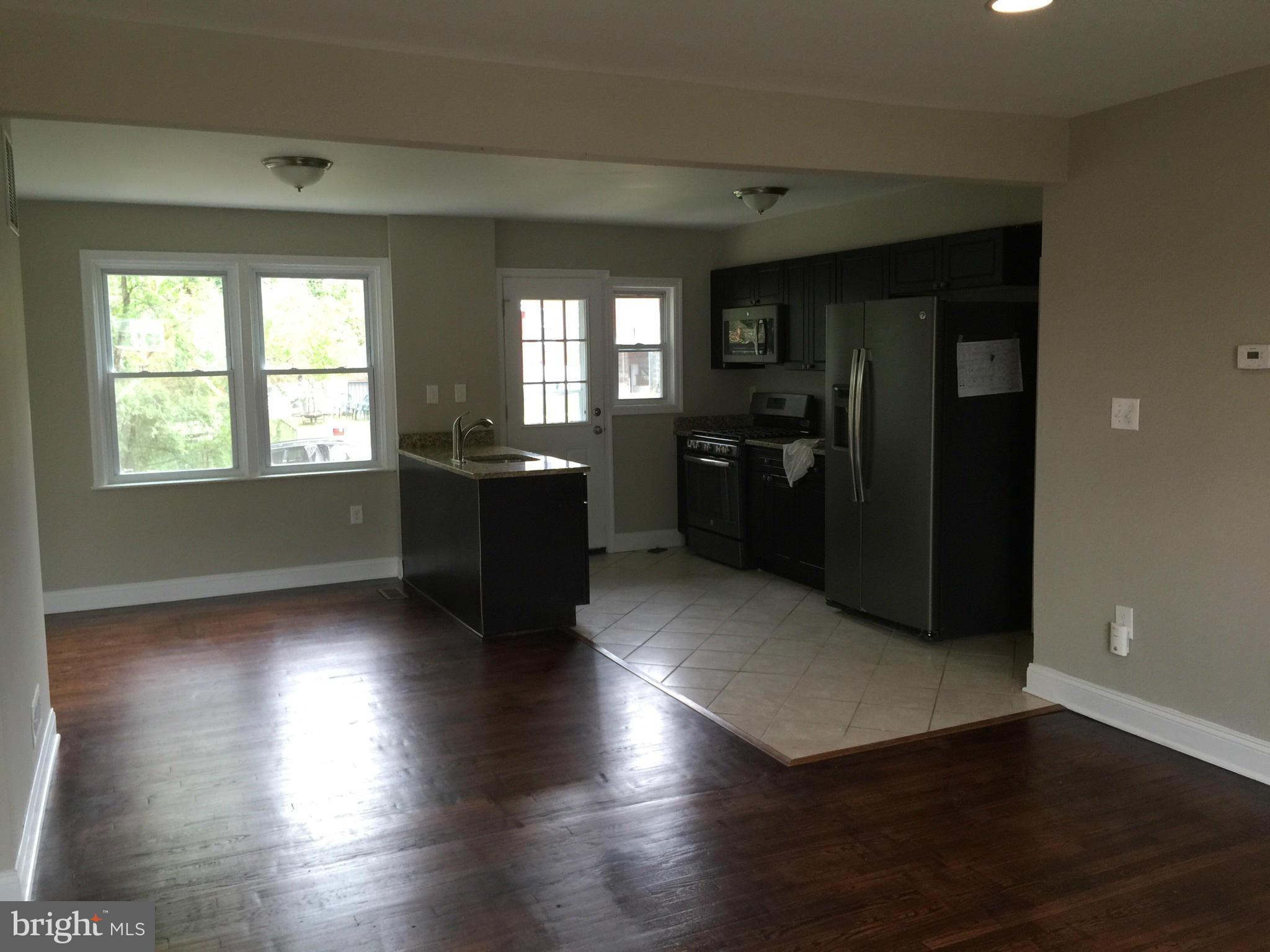 1021 Upnor Road Baltimore, MD 21212 - Photo 6 of 24 an empty room with wooden floor and windows