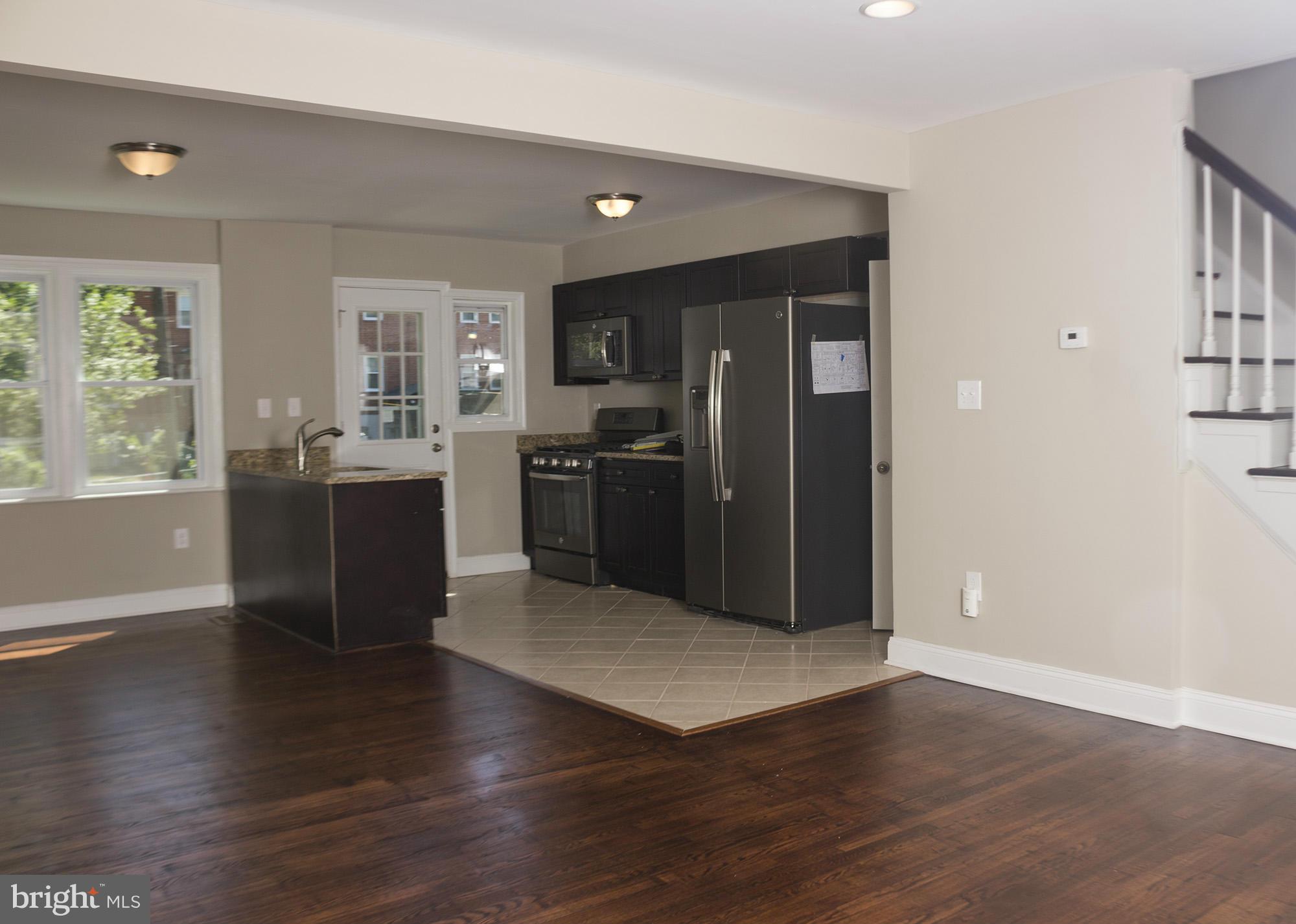 1021 Upnor Road Baltimore, MD 21212 - Photo 7 of 24 an empty room with wooden floor and windows
