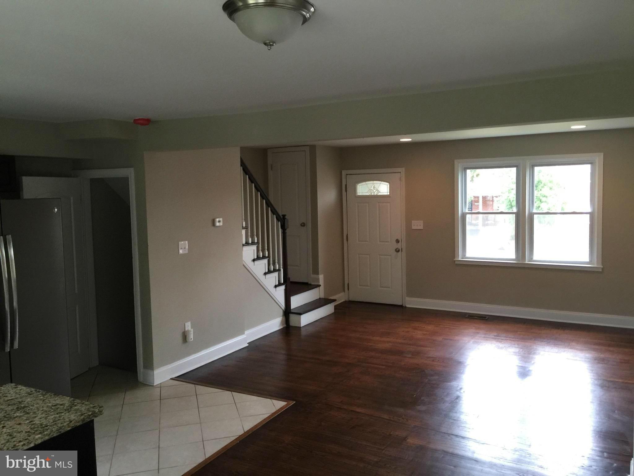 1021 Upnor Road Baltimore, MD 21212 - Photo 8 of 24 an empty room with wooden floor and windows